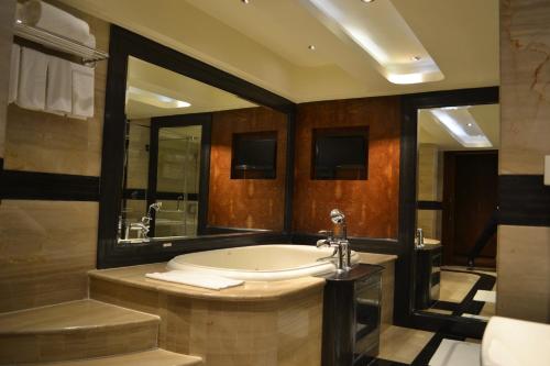 a bathroom with a large tub and a sink at Vivanta Hyderabad, Begumpet in Hyderabad