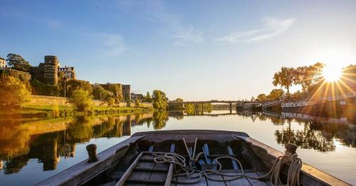 un barco en un río con puesta de sol en Logis de l'Hermitage, en Le Louroux-Béconnais