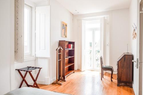 uma sala de estar com uma cadeira e um piso de madeira em Eighteen21 Houses - Casa de São Paulo em Lisboa