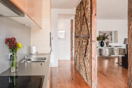 uma cozinha com uma parede de pedra e uma cozinha com um lavatório em Eighteen21 Houses - Casa de São Paulo em Lisboa