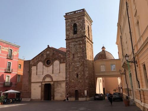 a large building with a clock tower in a street at La Scala del Sale in Iglesias