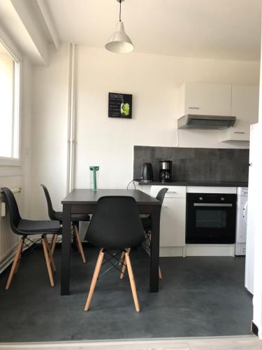 une cuisine avec une table et des chaises dans une pièce dans l'établissement L’URBAN - Appart Au Top !, à Metz