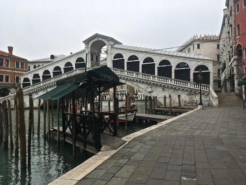 a bridge over a canal in a city at San Bortolomio near Suso Ice-cream in Venice
