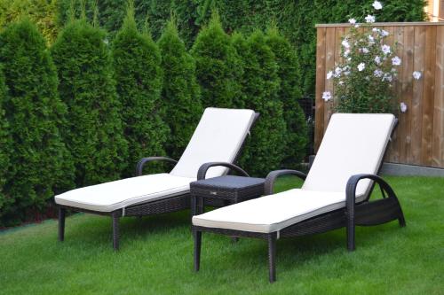 three chairs sitting on the grass in a yard at Pension Betty in Tábor