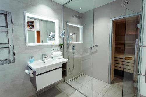 a bathroom with a sink and a glass shower at Passau - Suites in Passau