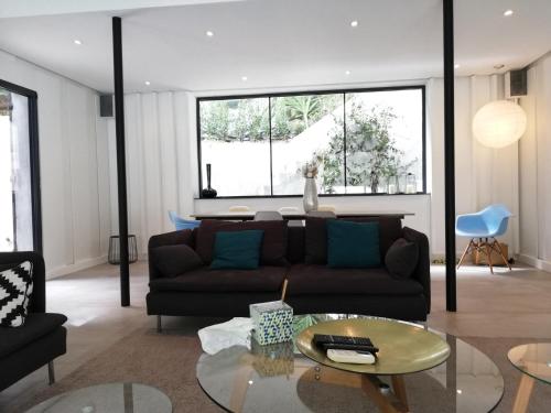 uma sala de estar com um sofá e uma mesa de vidro em Villa Le Ruisseau em Cannes