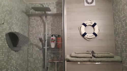 La salle de bains est pourvue d'une douche avec bouée de sauvetage et de serviettes. dans l'établissement WAW vakantie appartement, à Middelkerke