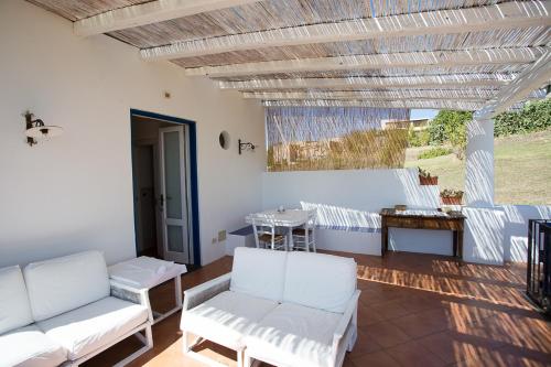 a living room with white chairs and a table at Rosa Dei Venti in Lipari