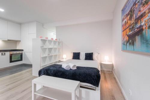 a white bedroom with a bed and a kitchen at Oporto Downtown View Apartment in Porto