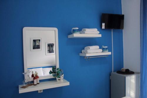 ein Bad mit einem Spiegel und einer blauen Wand in der Unterkunft Hotel Elena in Pyrgadikia