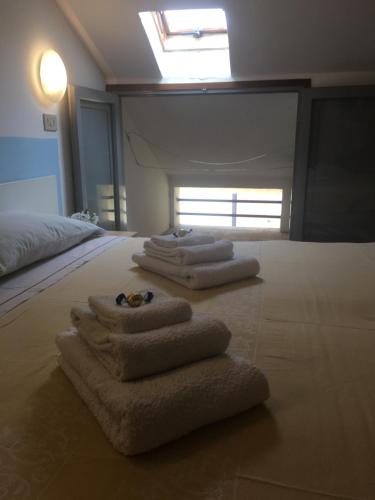 a room with three folded towels on a bed at Hotel Villa Rinaldini in Rimini