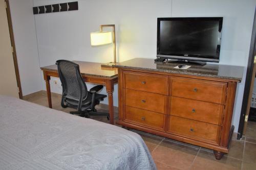 a bedroom with a desk and a television on a dresser at Lewis & Clark Resort in Yankton