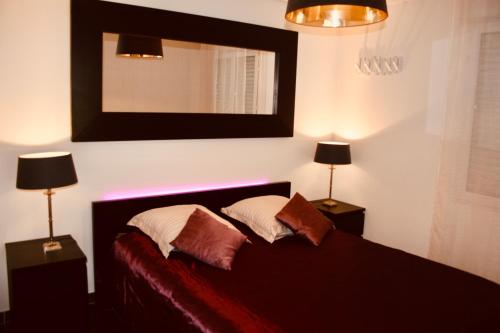 a bedroom with a bed with two lamps and a mirror at Carpe Diem in Beaulieu-sur-Mer