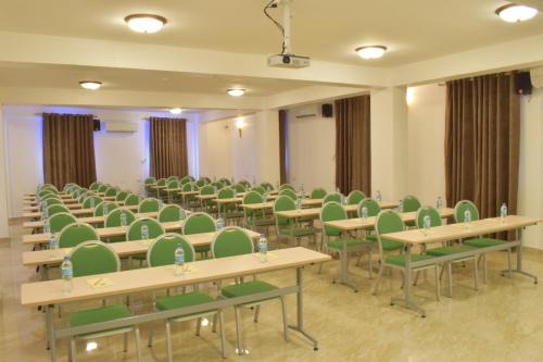 an empty room with tables and green chairs at Maru Maru Hotel in Zanzibar City