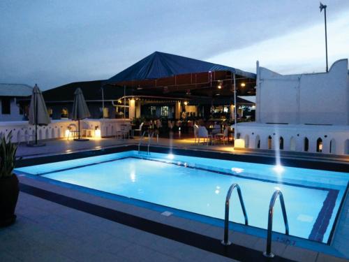 a large swimming pool at night with a building at Maru Maru Hotel in Zanzibar City
