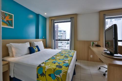 a bedroom with a bed and a desk and a television at Quality Hotel Manaus in Manaus