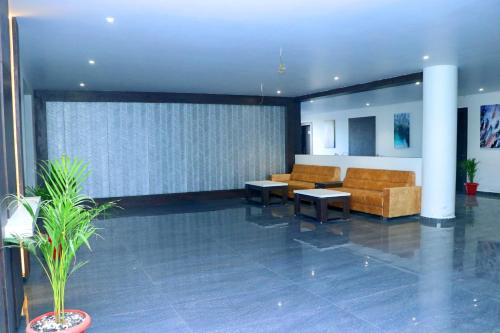 a lobby with a couch and tables in a building at THE GRAND ASTORIA SOMANTH by Shivalaya Darshanam in Somnath