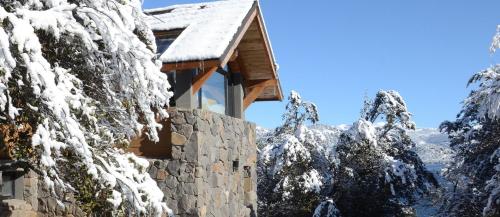 a mountain cabin covered in snow at Amarras in Villa Pehuenia