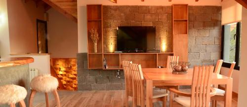 a kitchen and dining room with a wooden table and chairs at Amarras in Villa Pehuenia