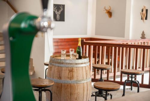 a barrel with a bottle of wine and some stools at Les gîtes d'Aure in Vielle-Aure