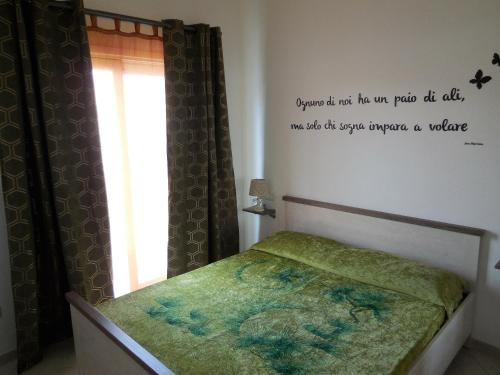 a bedroom with a bed with a sign on the wall at CASA VACANZE PAOLA SARDEGNA in Viddalba