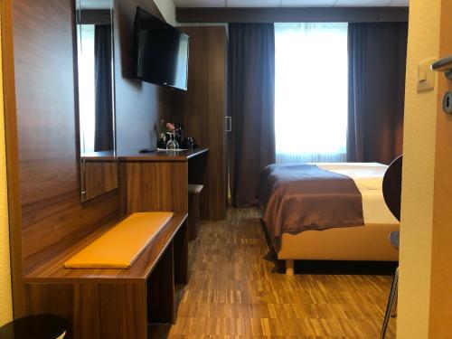 Hotel Post في كلكهايم: غرفه فندقيه سرير وتلفزيون