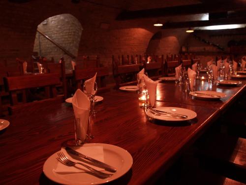 a long wooden table in a restaurant with plates and silverware at Vila Prezident in Sremski Karlovci
