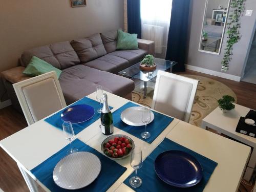 una mesa con platos y copas de vino en la sala de estar. en Appartement refait par architecte. Proche de la gare et le centre de Reims, en Reims