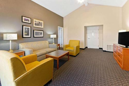 a living room with a couch and chairs and a tv at La Quinta Inn by Wyndham Santa Fe in Santa Fe