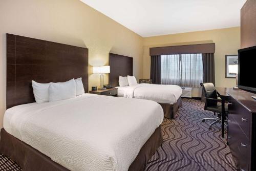 a hotel room with two beds and a flat screen tv at La Quinta by Wyndham Meridian / Boise West in Meridian