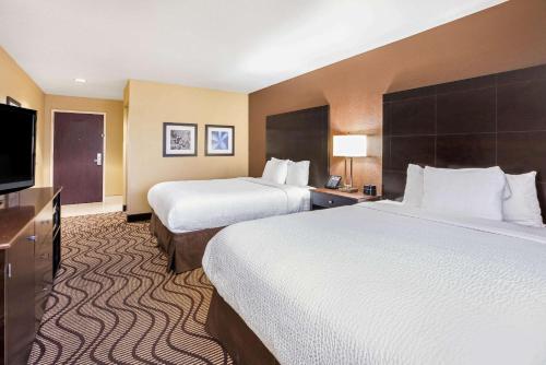 a hotel room with two beds and a flat screen tv at La Quinta by Wyndham Meridian / Boise West in Meridian
