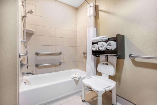 a bathroom with a tub and a toilet and a stool at La Quinta by Wyndham Meridian / Boise West in Meridian