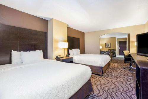 a hotel room with two beds and a flat screen tv at La Quinta by Wyndham Meridian / Boise West in Meridian
