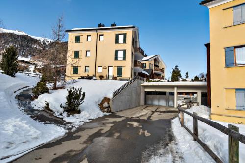 a house with a driveway in the snow at Chesa Roser - Samedan in Samedan