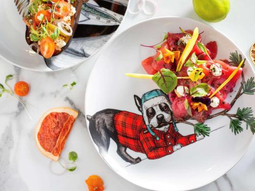 a plate of food with a dog in a sweater and a salad at Pullman London St Pancras in London