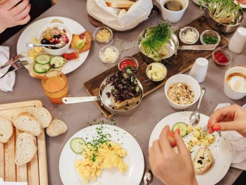 a table topped with plates of food and bread at Novotel Hildesheim in Hildesheim