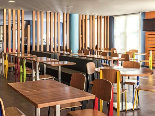 a dining room with wooden tables and chairs at ibis Sao Paulo Interlagos in Sao Paulo
