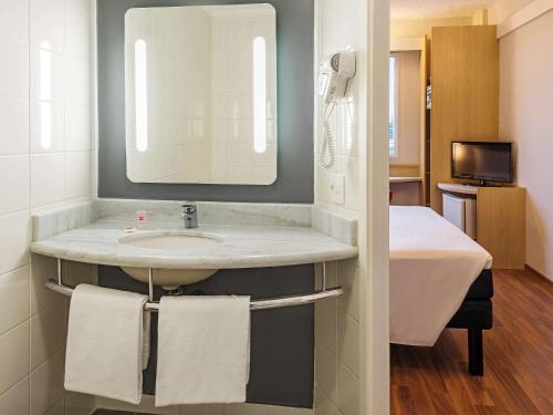 W łazience znajduje się umywalka i lustro. w obiekcie ibis Santo Andre w mieście Santo André
