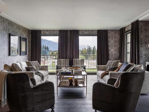 a living room with two couches and a table at Sofitel Queenstown Hotel & Spa in Queenstown