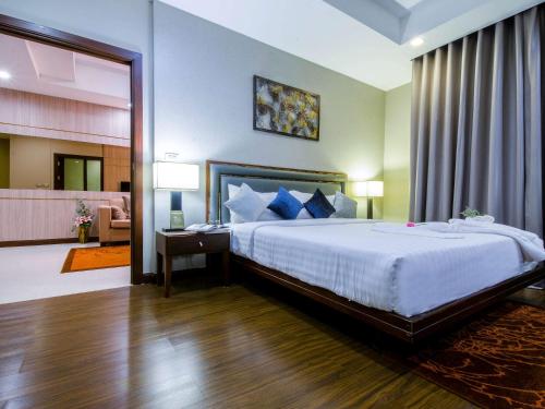 a bedroom with a large bed in a room at Grand Mercure Bangkok Asoke Residence in Bangkok