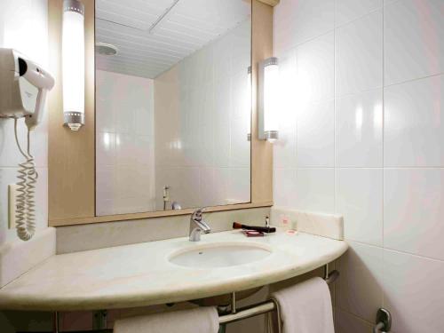 La salle de bains est pourvue d'un lavabo et d'un miroir. dans l'établissement Ibis Joao Pessoa Praia, à João Pessoa