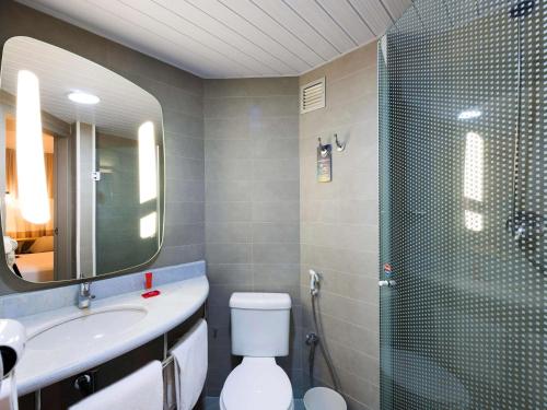 a bathroom with a shower and a toilet and a sink at ibis Navegantes Itajai in Itajaí