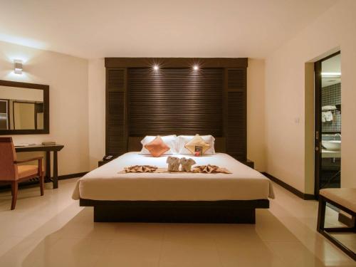 a bedroom with a bed with two stuffed animals on it at The Nouveau Chumphon Beach Resort And Golf in Chumphon