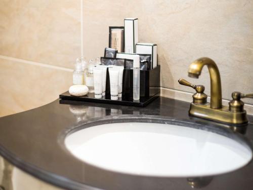 a bathroom sink with a faucet on a counter at WorldHotels Distinctive Woughton House Hotel in Milton Keynes