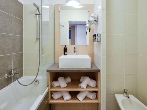 La salle de bains est pourvue d'un lavabo, de toilettes et d'une baignoire. dans l'établissement Aparthotel Adagio Monaco Monte Cristo, à Beausoleil