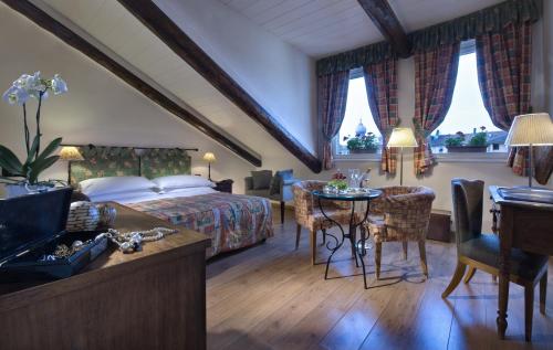 1 dormitorio con 1 cama, mesa y sillas en Best Western Hotel Piemontese, en Turín