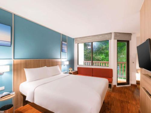 a bedroom with a white bed and a window at Ibis Phuket Patong in Patong Beach