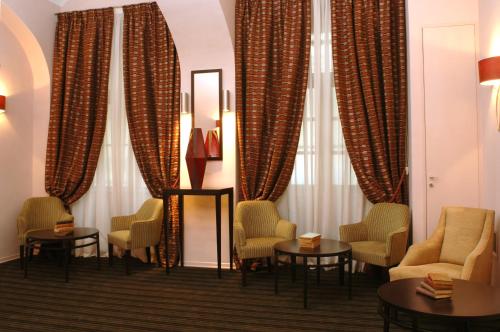 a waiting room with chairs and tables and curtains at Best Western Hotel Piemontese in Turin