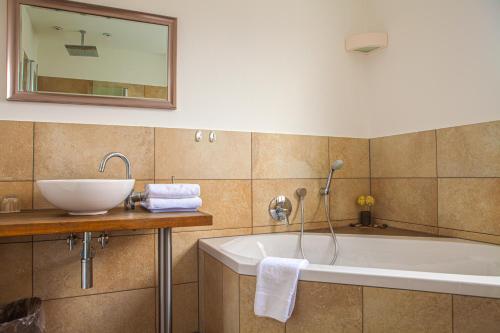 ein Badezimmer mit einem Waschbecken und einer Badewanne in der Unterkunft Hotel Kolb in Zeil