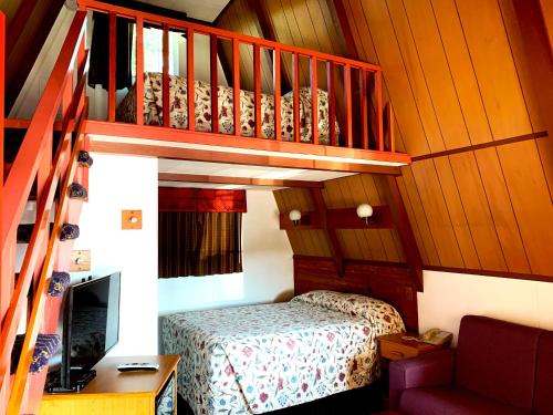 Un pequeño dormitorio con una cama y una escalera en The Ranch Motel en Oakland